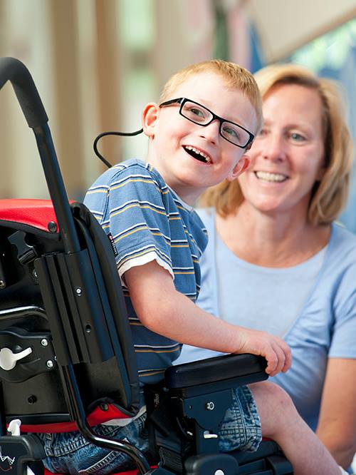 ילד מחייך בכסא גלגלים