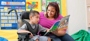 אשה מקריאה סיפור לילד בכסא גלגלים